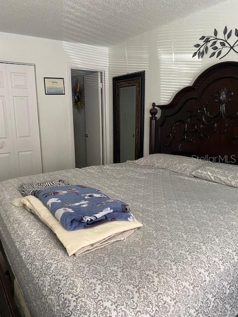 bedroom featuring a textured ceiling and a closet