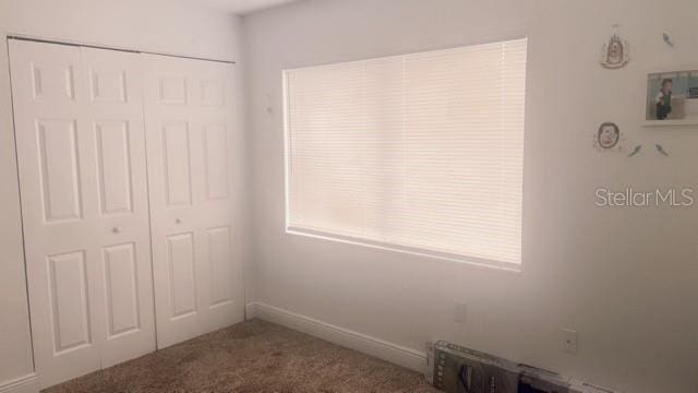 unfurnished bedroom featuring carpet floors and a closet