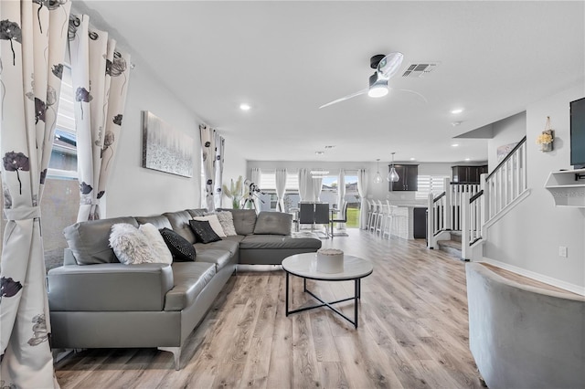 living room featuring light wood-type flooring and ceiling fan