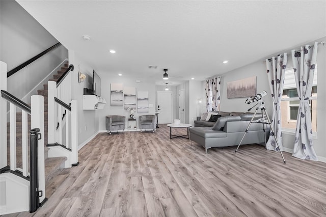 living room with light wood-type flooring and ceiling fan