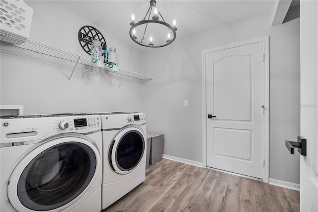 laundry room featuring light hardwood / wood-style floors, an inviting chandelier, and washer and clothes dryer