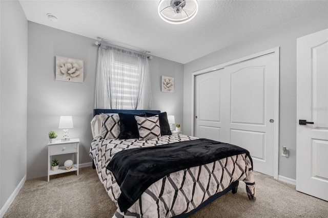 bedroom featuring carpet floors, a textured ceiling, and a closet