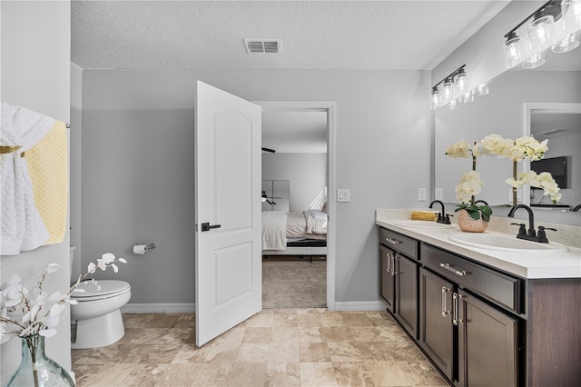 bathroom featuring a textured ceiling, vanity, and toilet