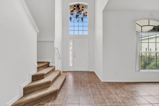 entryway featuring a high ceiling, an inviting chandelier, and tile patterned flooring