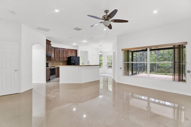 kitchen featuring black refrigerator, stainless steel range with electric cooktop, ceiling fan, and a center island