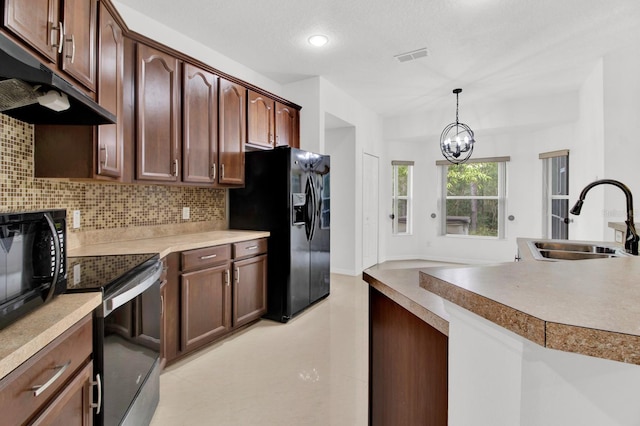 kitchen with black appliances, tasteful backsplash, decorative light fixtures, an inviting chandelier, and sink