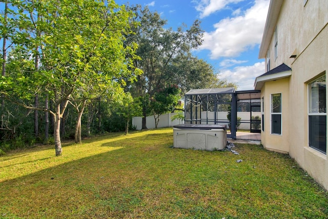 view of yard featuring glass enclosure and a swimming pool with hot tub