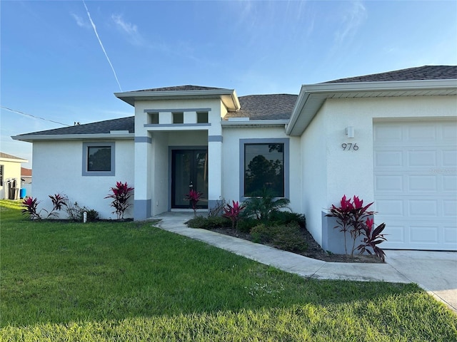 view of front of property with a shingled roof, a front yard, an attached garage, and stucco siding