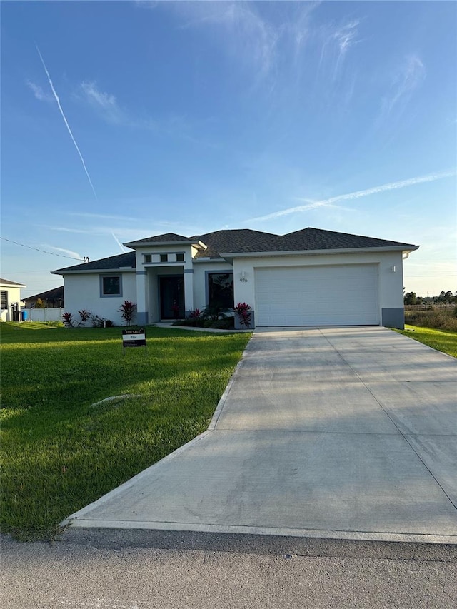 view of front of house featuring a garage, concrete driveway, a front lawn, and stucco siding