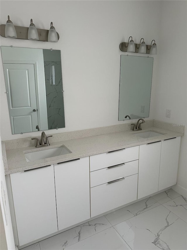 bathroom featuring double vanity, marble finish floor, and a sink