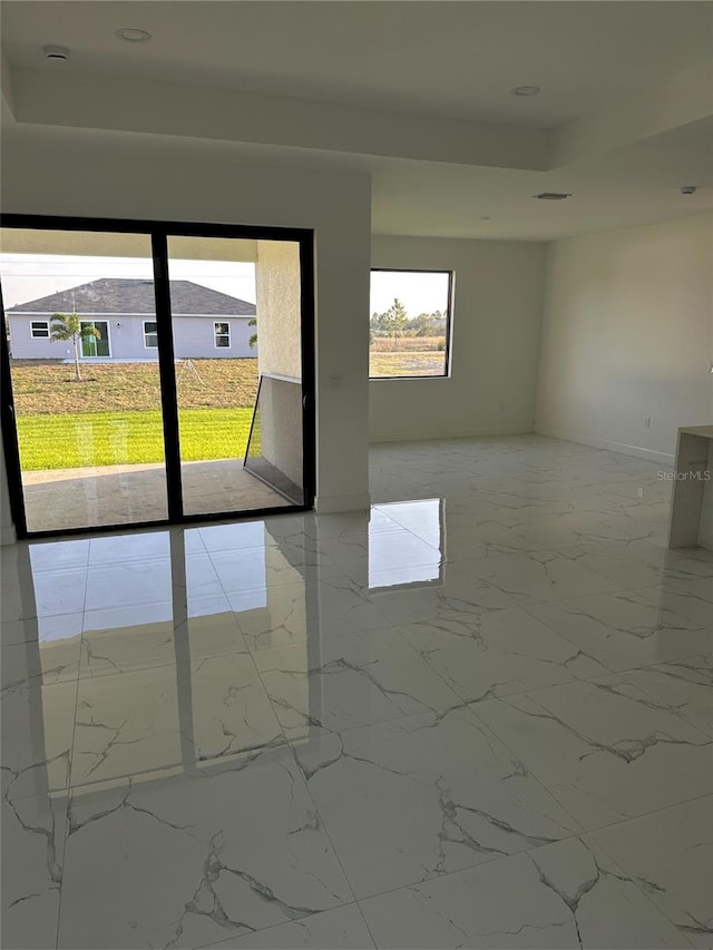 unfurnished room featuring marble finish floor, a tray ceiling, and recessed lighting