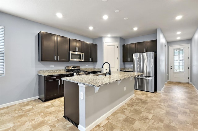 kitchen with dark brown cabinetry, a center island with sink, stainless steel appliances, and sink