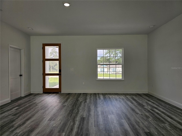 spare room with a wealth of natural light and dark hardwood / wood-style floors