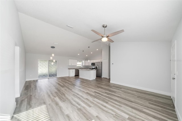 unfurnished living room featuring light hardwood / wood-style floors, ceiling fan, and vaulted ceiling