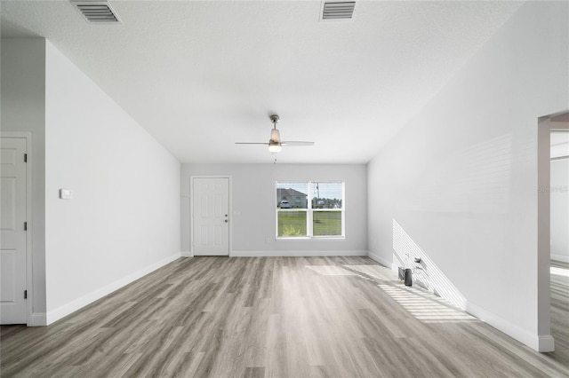 unfurnished living room with ceiling fan, a textured ceiling, and light hardwood / wood-style flooring