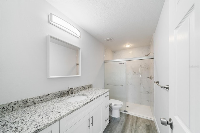 bathroom featuring vanity, hardwood / wood-style floors, toilet, and walk in shower