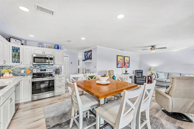 dining area with ceiling fan, a textured ceiling, and light wood-type flooring