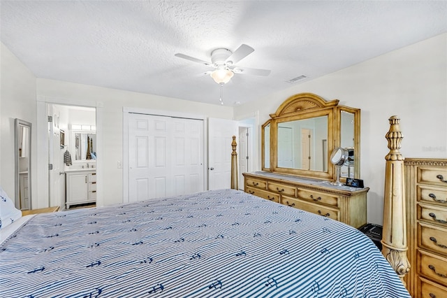 bedroom featuring a closet, ensuite bath, a textured ceiling, and ceiling fan