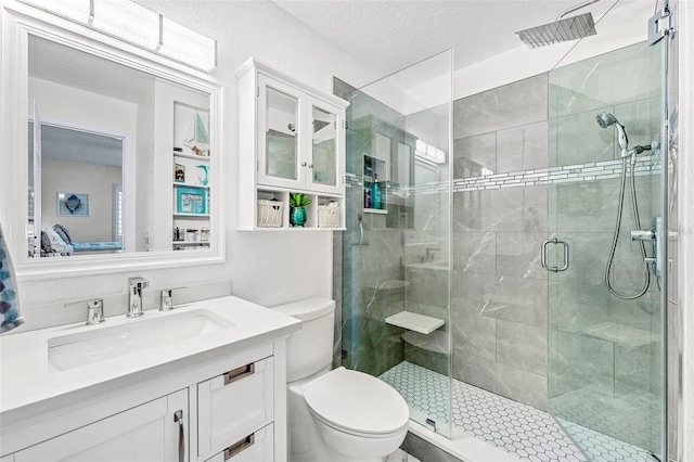 bathroom with toilet, a textured ceiling, vanity, and a shower with door