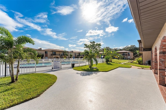 view of home's community with a yard, a patio, and a pool