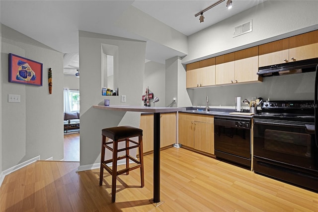 kitchen featuring sink, light brown cabinets, light hardwood / wood-style floors, track lighting, and black appliances