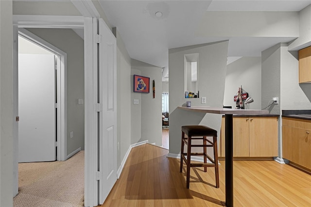 kitchen with light brown cabinetry and light hardwood / wood-style floors