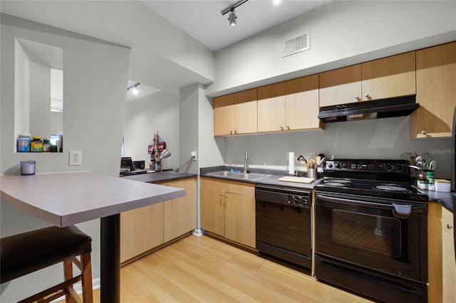 kitchen featuring sink, light hardwood / wood-style flooring, kitchen peninsula, light brown cabinetry, and black appliances