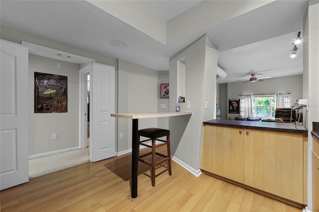 kitchen featuring ceiling fan, light brown cabinetry, and light wood-type flooring