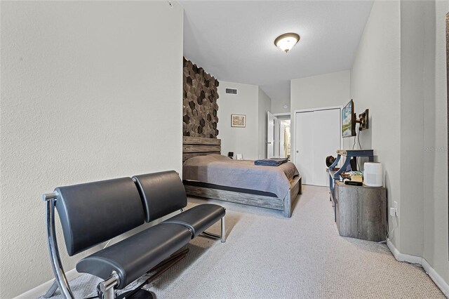 bedroom with connected bathroom and light colored carpet