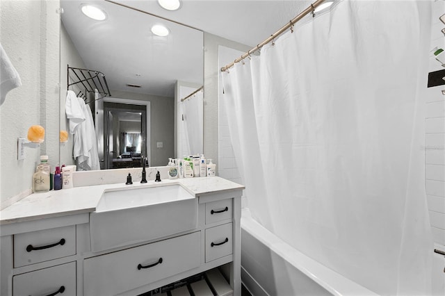 bathroom featuring shower / tub combo and vanity