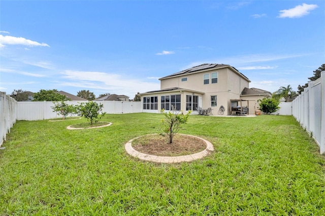 rear view of property with a yard, a sunroom, and a patio area