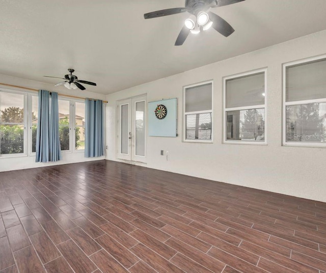 unfurnished living room with french doors, dark hardwood / wood-style floors, and ceiling fan