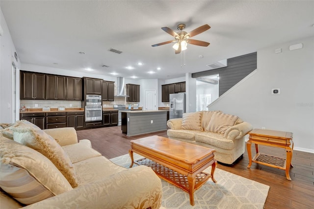 living room with dark wood-type flooring and ceiling fan