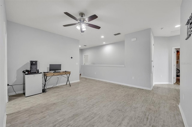 home office with light wood-type flooring and ceiling fan