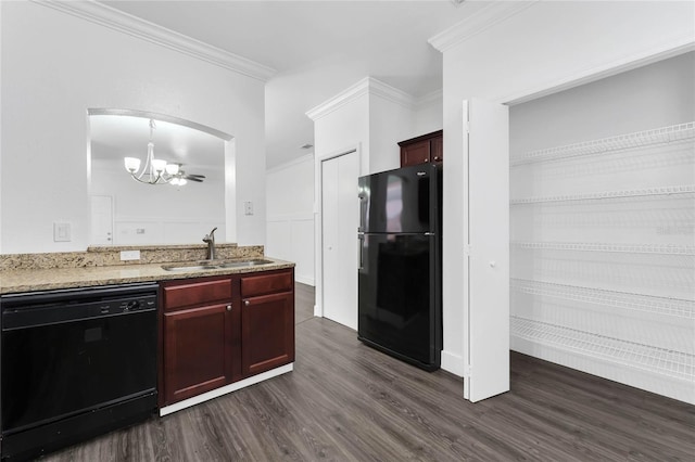 kitchen featuring dark wood finished floors, a sink, crown molding, black appliances, and a notable chandelier
