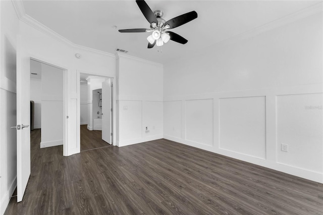 unfurnished bedroom featuring a decorative wall, crown molding, dark wood-type flooring, and visible vents