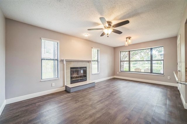 unfurnished living room featuring a textured ceiling, plenty of natural light, and dark hardwood / wood-style flooring