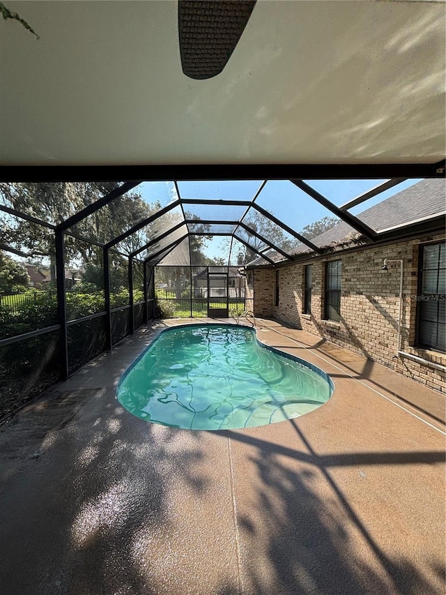 view of pool featuring glass enclosure and a patio area