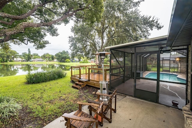 view of yard featuring a pool side deck with water view, a patio, and a lanai