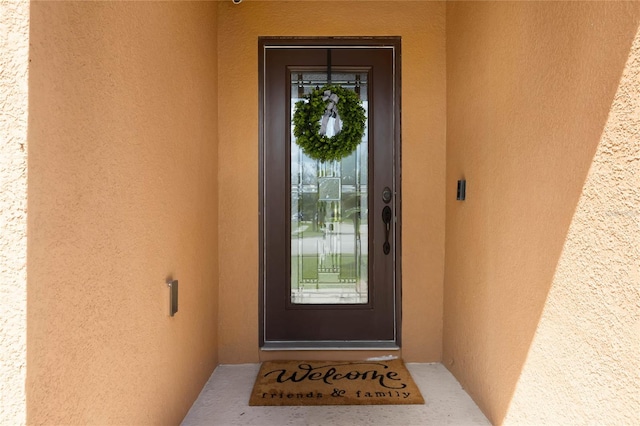 entrance to property featuring stucco siding