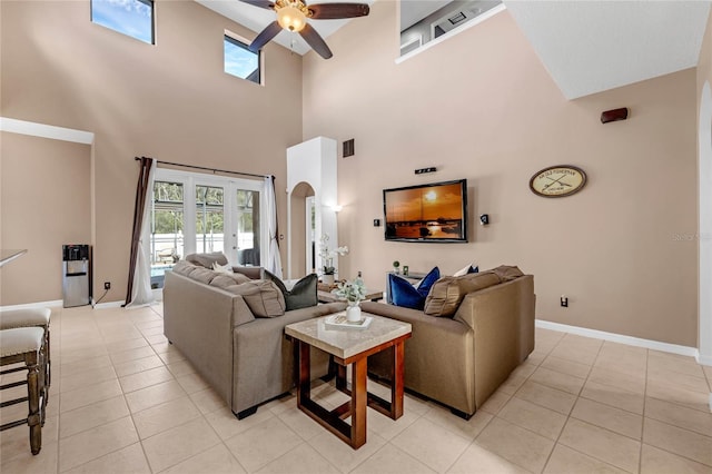 living room with light tile patterned flooring, a high ceiling, and ceiling fan