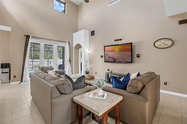 tiled living room featuring a towering ceiling