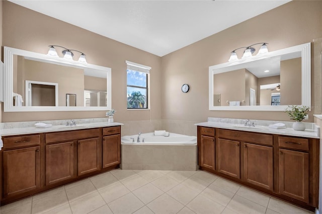 bathroom with vanity, a relaxing tiled tub, ceiling fan, and tile patterned floors