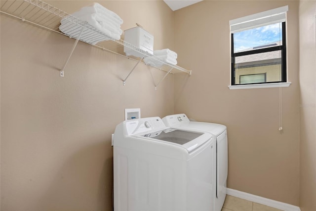 laundry room featuring laundry area, light tile patterned floors, baseboards, and washing machine and clothes dryer