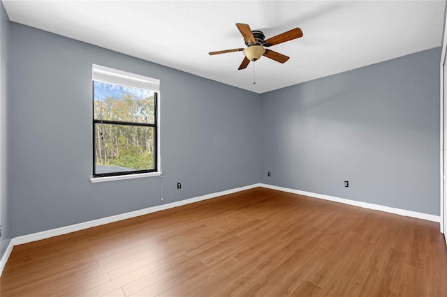 unfurnished room featuring a ceiling fan, baseboards, and wood finished floors