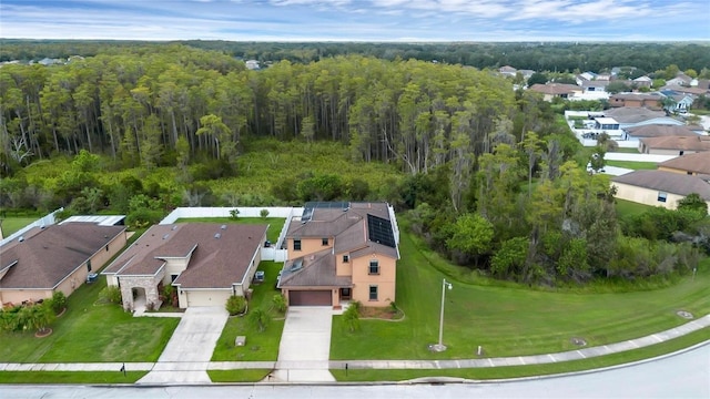 drone / aerial view featuring a residential view and a wooded view