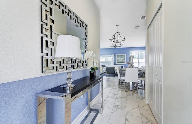 hallway with an inviting chandelier