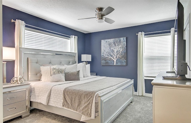 bedroom with ceiling fan, a textured ceiling, and light carpet