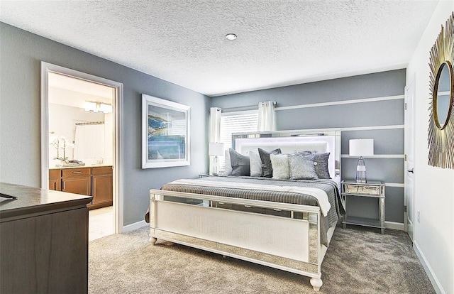 bedroom featuring ensuite bathroom, carpet floors, and a textured ceiling