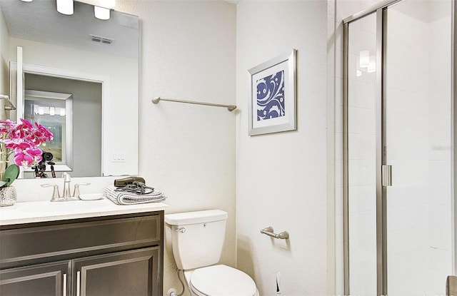 bathroom featuring vanity, toilet, and a shower with door